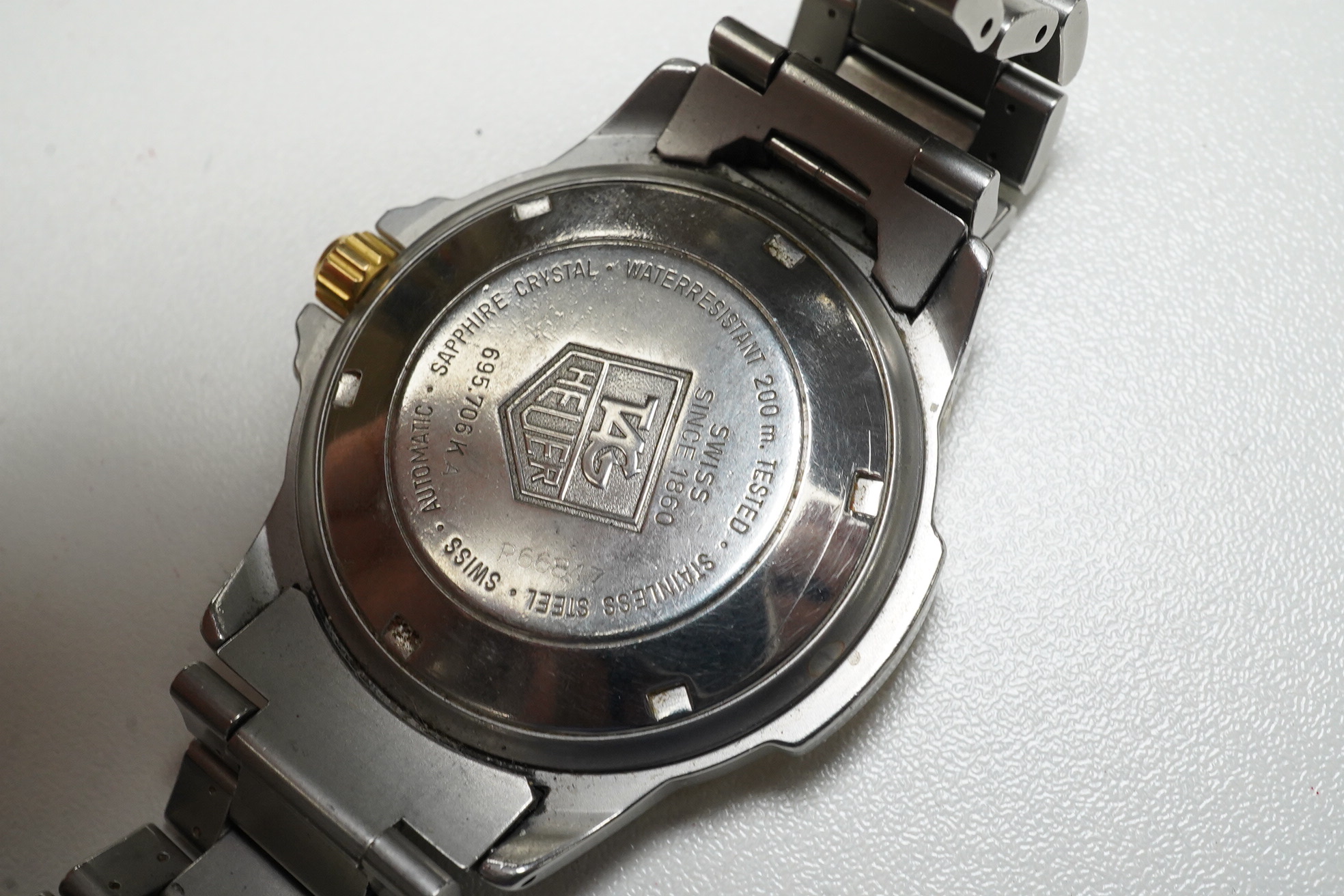 A gentleman's stainless steel Tag Heuer automatic wrist watch, with baton numerals and date aperture, case diameter 38mm, together with a battery operated winder. Condition - poor to fair